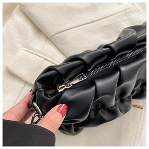 Close-up of black pleated texture bag with silver metal zipper on suit fabric