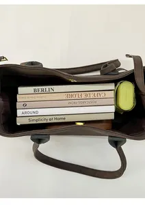 Vertical top view showing the spacious interior of a brown tote bag with daily items