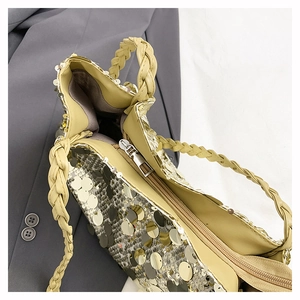 Detailed close-up of large golden sequins and the internal zipper closure of the bag