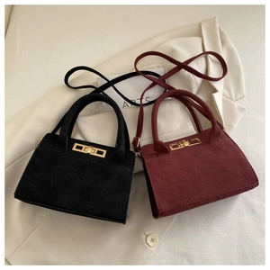Dettaglio di borse vintage opache in nero e bordeaux con chiusure girevoli dorate