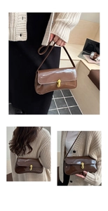 Detail of glossy brown patent leather shoulder bag featuring a gold metal buckle closure