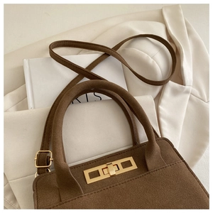 Detail of vintage matte brown suede handbag with golden rectangular turn-lock closure