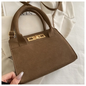 Detail of vintage brown suede handbag with gold square lock and premium matte texture