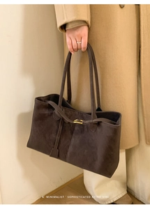 Detail of vintage matte brown tote bag with slim leather belt and gold hardware