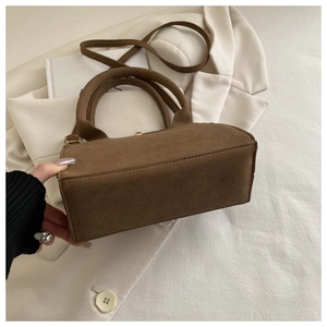 Detail of vintage matte brown leather tote bag with round handle and metal clasp