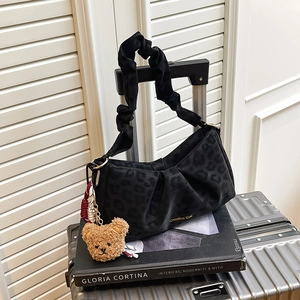 Leopard print underarm bag with ruffled strap and teddy bear charm on silver suitcase