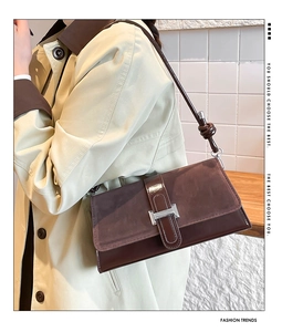 Close-up of retro burgundy shoulder bag with silver buckle and leather knot shoulder strap