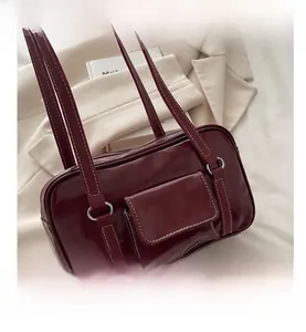 Detailed view of deep red vintage bowling bag with distinctive white contrast stitching