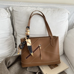 Retro brown leather tote bag with contrast stitching and decorative silk scarf