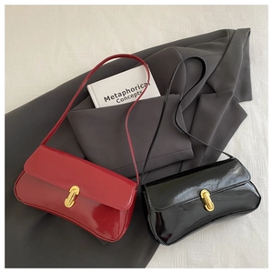 Detail view of red and black patent leather shoulder bags with gold hardware lock