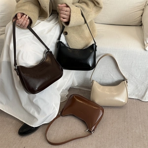 Retro half-moon hobo bag in four colors displayed with a model in a French chic style