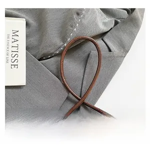 Macro shot of brown frosted leather handbag with unique knotted strap design
