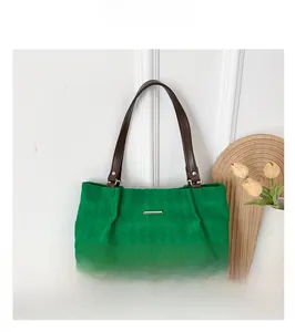Dettaglio borsa tote verde smeraldo con trama trapuntata e dettaglio in metallo oro