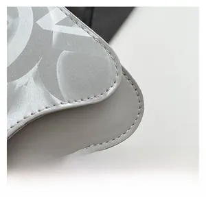 Macro detail of light gray crossbody bag showing premium stitching and textured synthetic leather