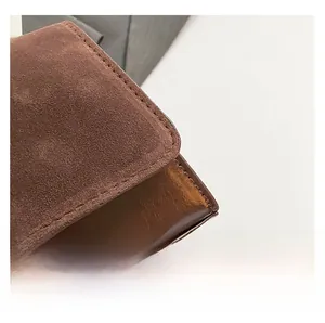 Detailed macro view of dark brown suede stitching on the retro underarm bag fabric