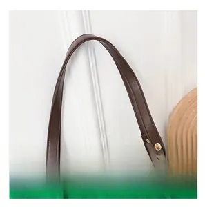 Dettaglio della borsa tote in maglia verde con tracolla in pelle marrone e borchie oro