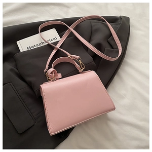 Sac à main trapèze rose minimaliste avec motif cerise sur fond de blazer gris élégant
