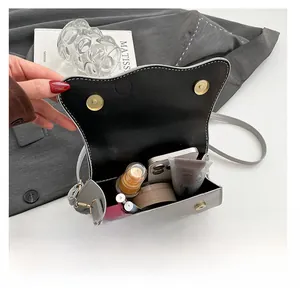 Interior view of small grey shoulder bag showing capacity for phone and cosmetics