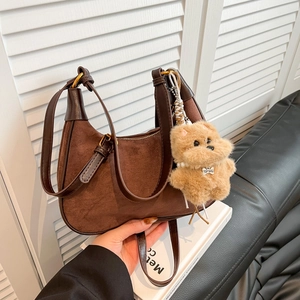 Brown suede hobo bag with leather trim, dual straps and a plush dog pendant accessory
