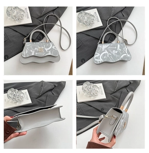 Detail of grey crossbody bag with letter print, wave edge bottom and mini metal logo