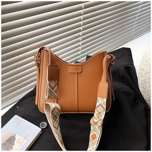 Brown leather crossbody bag with vintage design and geometric patterned wide strap