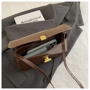 Interior view showing the storage capacity of the brown patent leather bag with gold buckle