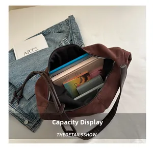 Interior view showing the large capacity of the brown suede shoulder bag with books