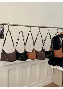 Dettaglio di borse a mezzaluna in pelle scamosciata vintage con catene metalliche
