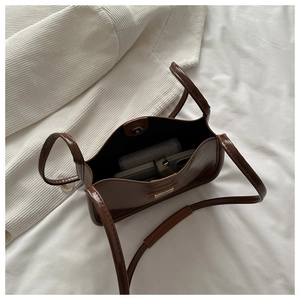 Vue intérieure d'un sac à bandoulière en simili cuir marron avec grand compartiment