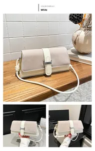 Detail of white vintage underarm bag with silver H-buckle and mixed suede textures
