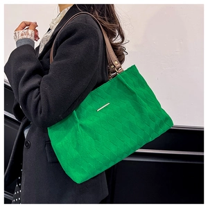 Dettaglio della borsa trapuntata verde brillante con tracolla in pelle marrone e finiture oro