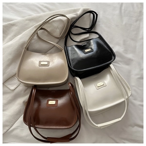 Detail of four small crossbody bags in beige, black, brown and cream colors with gold logo