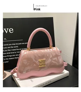 Close-up of pink leather handbag featuring unique wavy bottom edge and gold logo buckle