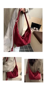 Detail of burgundy suede hobo bag with zip closure and knotted strap on a wooden bench