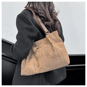Dettaglio della borsa tote in tela cammello con motivo a rombi e tracolla in pelle