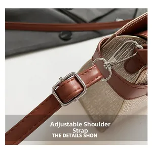 Close-up of adjustable brown leather shoulder strap with silver metal buckle and hooks
