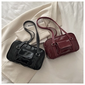 Detail view of vintage leather underarm bags with white contrast stitching and front pockets