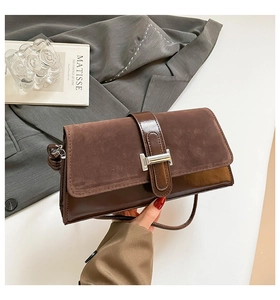 Detail of vintage brown shoulder bag showing textured faux leather and silver metal clasp
