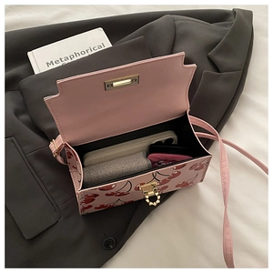 Détail de l'intérieur du sac à bandoulière imprimé cerise montrant sa grande capacité de rangement