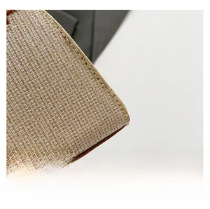 Detailed macro view of woven metallic fabric and precise stitching on a small square bag