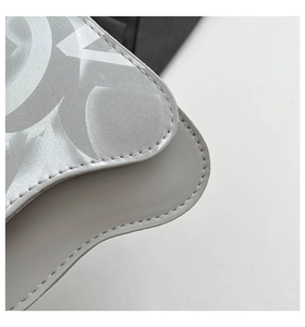 Close-up of grey leather bag with silver patterned silk overlay and fine white stitching