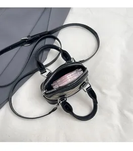 Internal view of a mini printed shell bag showing space for a makeup compact and lipstick