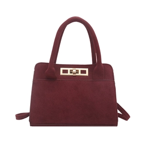 Minimalist burgundy suede tote bag with gold metal twist lock and shoulder strap