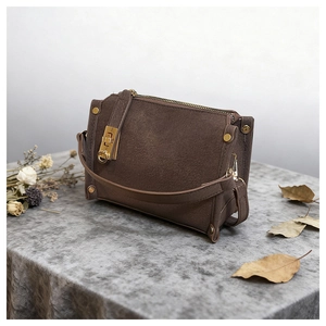 Dettaglio borsa a tracolla vintage marrone scuro con eleganti finiture in oro