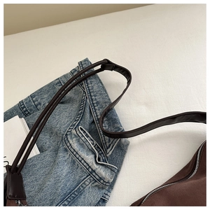 Detail of dark brown suede tote bag featuring fine stitching and smooth leather strap