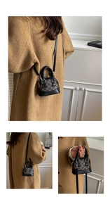 Detailed view of mini shell bag showing vintage print, dual handles and black crossbody strap