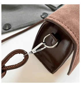 Detailed macro of brown shoulder bag with suede and patent leather stitching finish