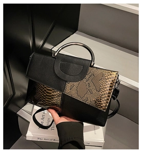 Detail der Schlangenmuster-Kontrast auf schwarzer Lederhandtasche mit silbernem Metallgriff