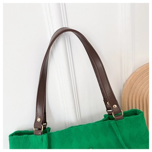 Dettaglio della borsa tote in tela trapuntata verde con tracolla in pelle marrone
