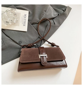 Close-up of vintage brown baguette bag featuring suede patchwork and silver buckle